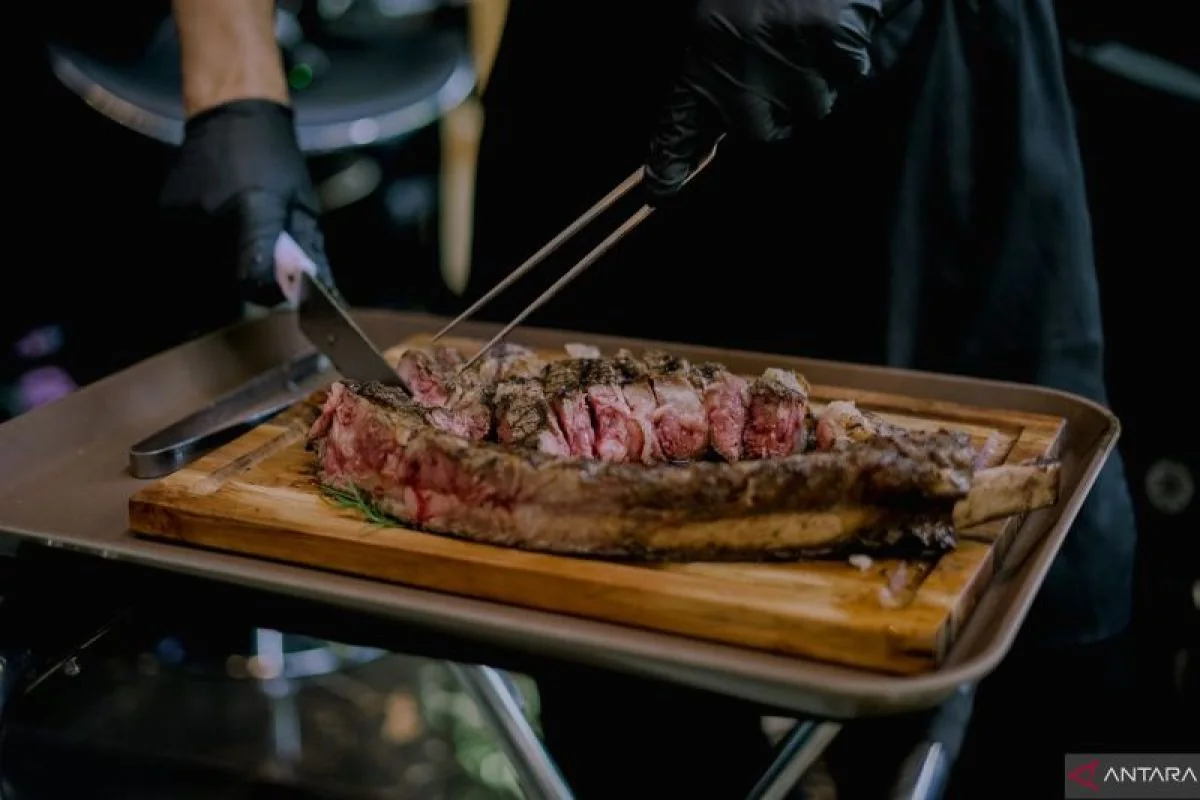 Steak being sliced on a serving board at T.Bene