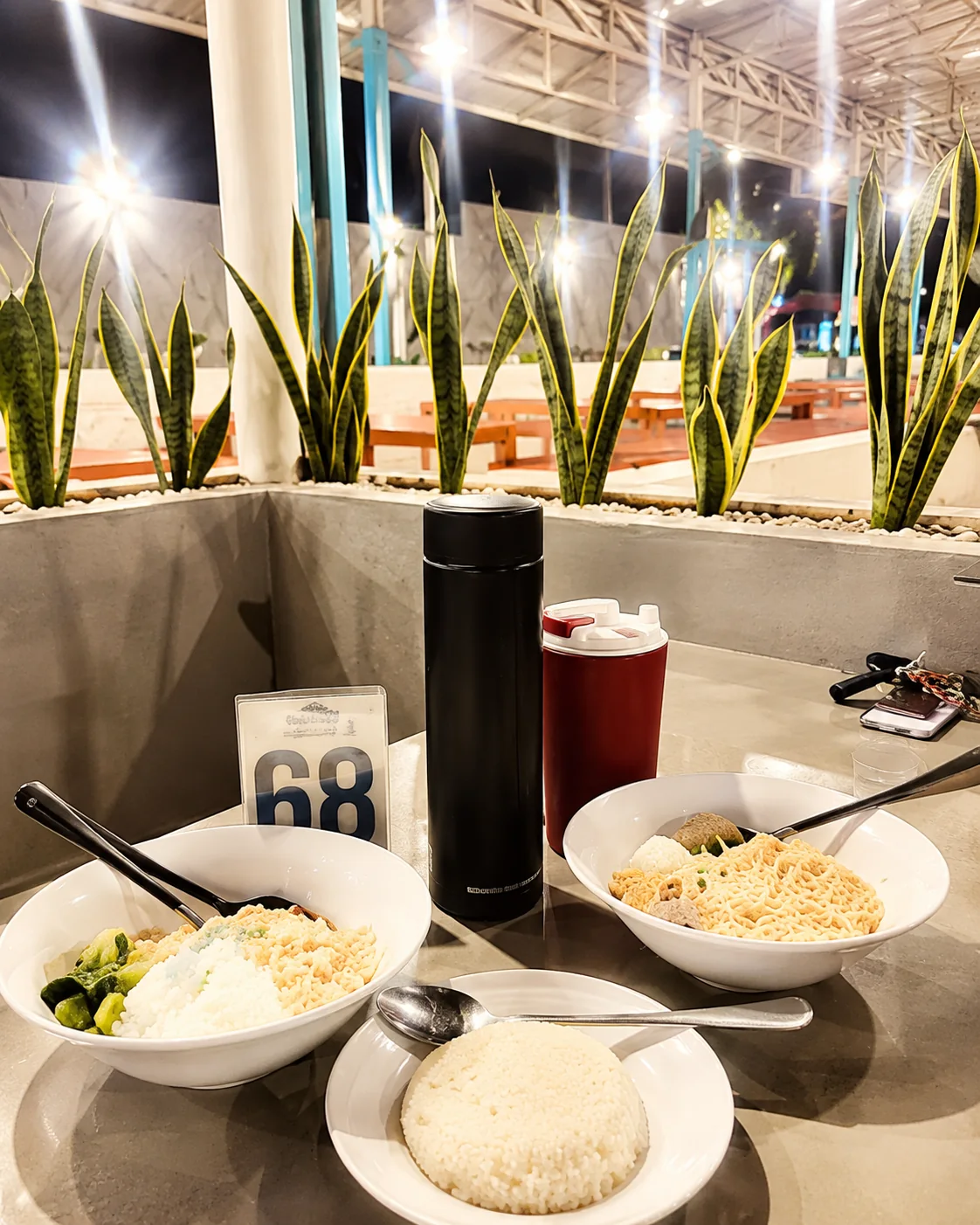 Drinks and snacks on an outdoor table at Warkop Kelawai
