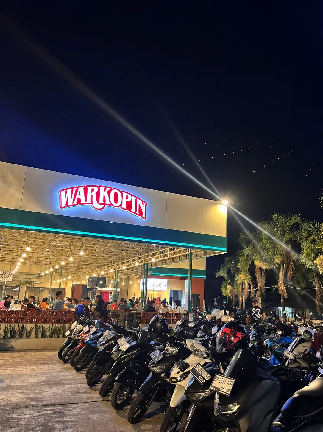 Warkopin storefront and outdoor seating at night